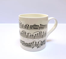Load image into Gallery viewer, Music gift ideal for classical music fans. Elegant bone china mug with a section of Mendelssohn's Violin Concerto printed on in black. This fabulous mug is perfect for any violin player or music lover. A combination of a full capacity of 310ml and a subtle lip and classic handle design makes this mug both comfortable and stylish. Microwave and dishwasher safe. Height 85mm; Diameter 77mm. View from right 2 thechord.co.uk