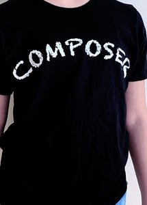 Black T-shirt with white handchalked effect writing of "Composer" in white. Shown on model close-up view