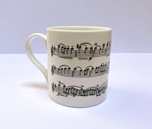 Load image into Gallery viewer, Music gift ideal for classical music fans. Elegant bone china mug with a section of Mendelssohn&#39;s Violin Concerto printed on in black. This fabulous mug is perfect for any violin player or music lover. A combination of a full capacity of 310ml and a subtle lip and classic handle design makes this mug both comfortable and stylish. Microwave and dishwasher safe. Height 85mm; Diameter 77mm. View from left 3 thechord.co.uk