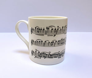 Music gift ideal for classical music fans. Elegant bone china mug with a section of Mendelssohn's Violin Concerto printed on in black. This fabulous mug is perfect for any violin player or music lover. A combination of a full capacity of 310ml and a subtle lip and classic handle design makes this mug both comfortable and stylish. Microwave and dishwasher safe. Height 85mm; Diameter 77mm. View from left 3 thechord.co.uk