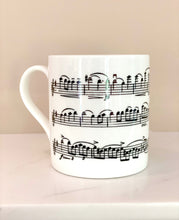 Load image into Gallery viewer, Music gift ideal for classical music fans. Elegant bone china mug with a section of Mendelssohn&#39;s Violin Concerto printed on in black. This fabulous mug is perfect for any violin player or music lover. A combination of a full capacity of 310ml and a subtle lip and classic handle design makes this mug both comfortable and stylish. Microwave and dishwasher safe. Height 85mm; Diameter 77mm. View from left thechord.co.uk 