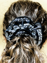 Load image into Gallery viewer, Musical hair tie scrunchie. White music score on black material.  Hand-made, large size (approx 15cm diameter). Shown on model.